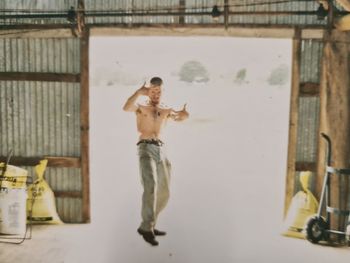 Full length of shirtless man standing at home