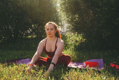 Portrait of young woman sitting on field