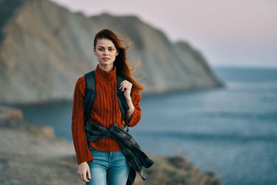 Portrait of beautiful young woman standing in sea