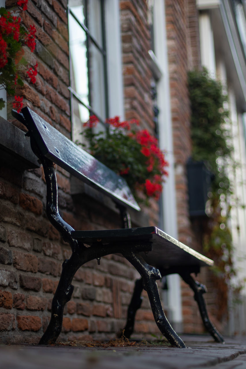 EMPTY BENCH AGAINST WALL IN BUILDING