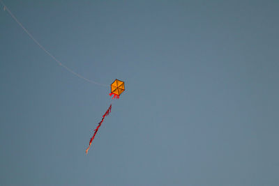 Low angle view of kite flying against clear sky