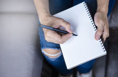 Midsection of man reading book on paper