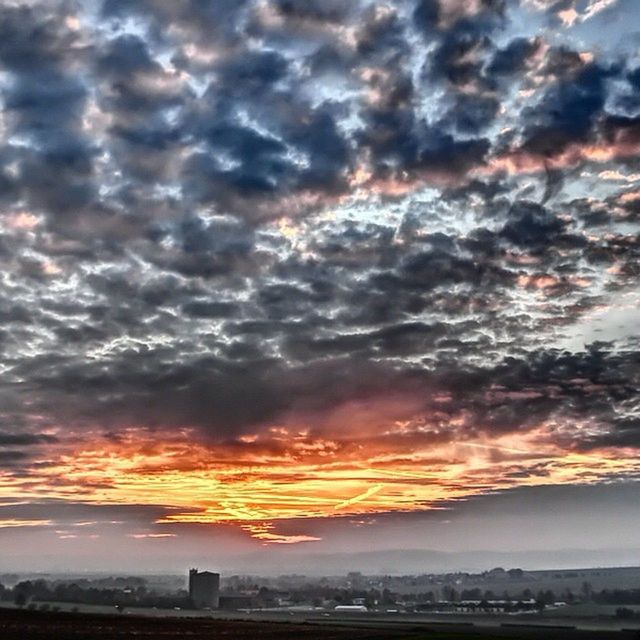 sunset, cloud - sky, sky, orange color, cloudy, dramatic sky, weather, building exterior, scenics, beauty in nature, architecture, built structure, overcast, landscape, nature, cloud, city, tranquil scene, atmospheric mood, silhouette