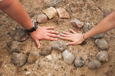 High angle view of hands on rock