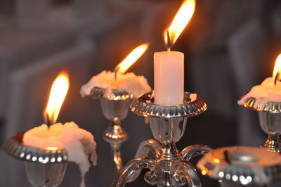 Close-up of burning candles in holder