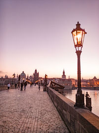 People on street light in city at sunset