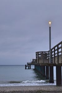 Pier over sea against sky at dusk