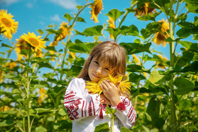 Low angle view of girl wearing hat standing in farm