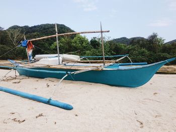 Boat moored on shore against sky