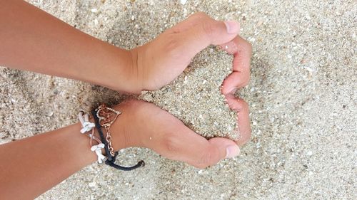 Close-up of woman hand on sand at beach