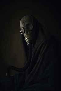 Man wearing gas mask against black background