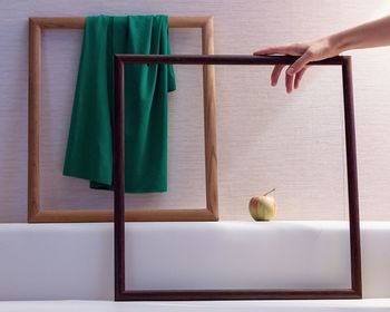 Cropped hand holding frame against apple 