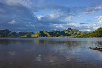 Scenic view of lake by mountains against sky