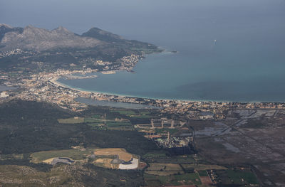 High angle view of townscape by sea against sky