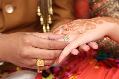 Cropped image of bridegroom inserting ring in bride finger