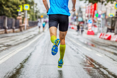 Low section of man running on road