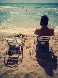 Rear view of woman sitting on beach