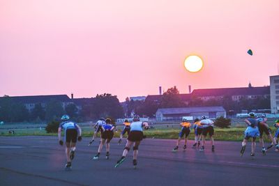 People walking on road at sunset