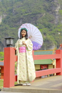 Rear view of woman holding umbrella