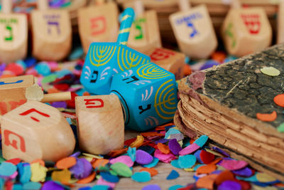 Close-up of colorful confetti and religious wooden toys on table