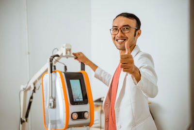 Portrait of young man with suitcase in hospital