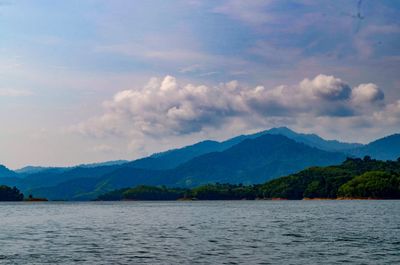 Scenic view of lake by mountains against sky