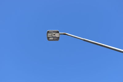 Low angle view of street light against blue sky