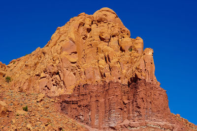 Low angle view of rock formations against blue sky