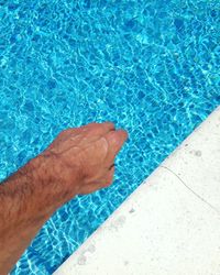 Low section of man swimming in pool