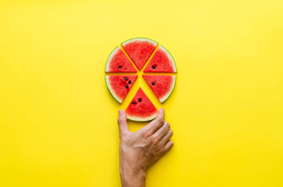 Hand taking a piece of watermelon that cut like pizza. minimal summer concept.