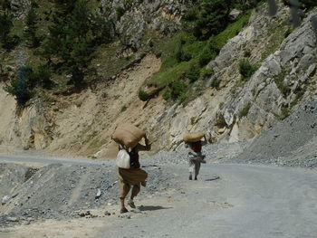 Rear view of people walking on road