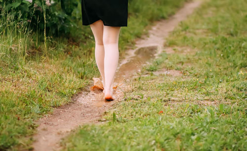 Low section of woman standing on field