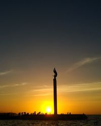 Silhouette of statue at sunset