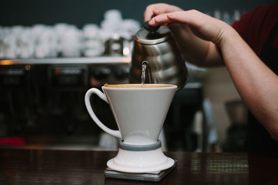 Midsection of man making coffee