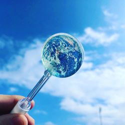 Person holding umbrella against blue sky