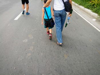 Low section of people walking on road