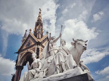 Low angle view of statue against building against sky