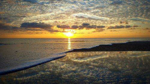 Scenic view of beach against sky during sunset