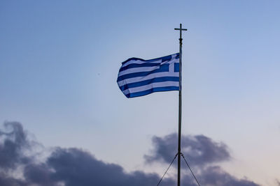 Low angle view of greek flag against blue sky