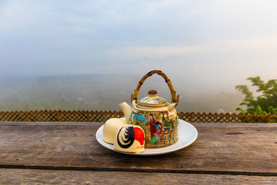 Stuffed toy on table against sky