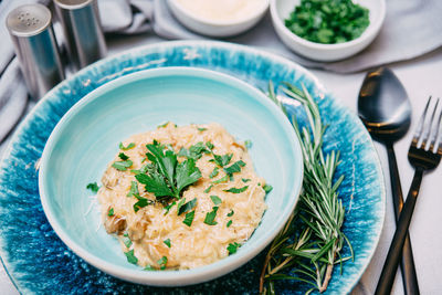 Portion of risotto with grated cheese and mushroom pieces. with fresh chopped parsley leaves.