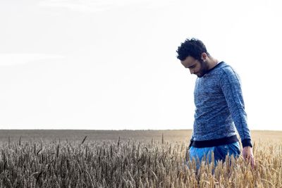 Man standing in farm against sky