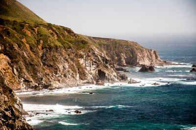 Scenic view of sea and mountains against clear sky