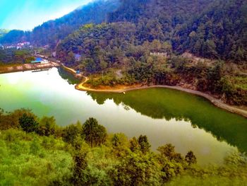 Scenic view of lake by trees against sky