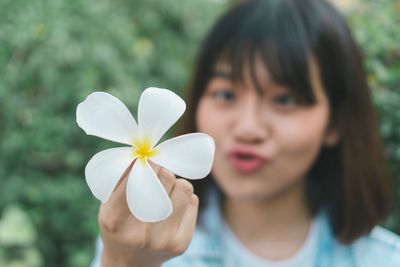 Close-up portrait of woman holding flowering plant