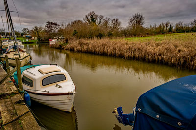 Sailboats moored on lake against sky