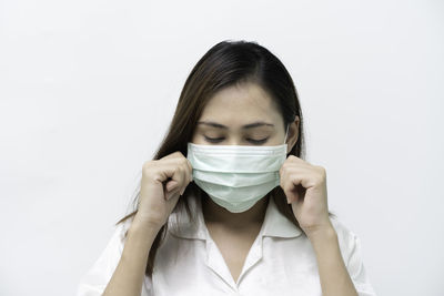 Portrait of young woman against white background