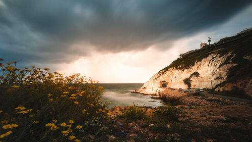 Scenic view of sea against cloudy sky during sunset