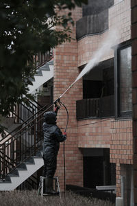 Rear view of man standing against waterfall