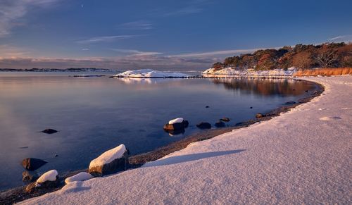 Scenic view of lake against sky during winter